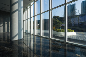 Obraz premium Modern office building lobby with floor-to-ceiling windows and polished marble flooring