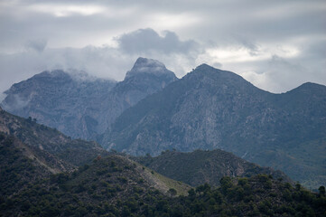 Scenic view of surrounding mountains and picturesque village from a hiking trail along an old irrigation ditch in Frigiliana, Spain.