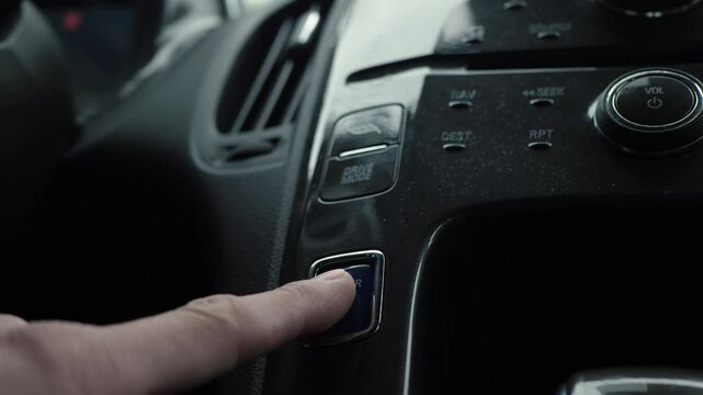 Button activation moment. Driver presses start button today. Vehicle ignition as driver begins journey. Closeup of driver activating vehicle by pressing illuminated start button on dashboard