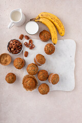Fototapeta premium Banana muffins with pecan nuts freshly baked on a cooling rack overhead with copy space
