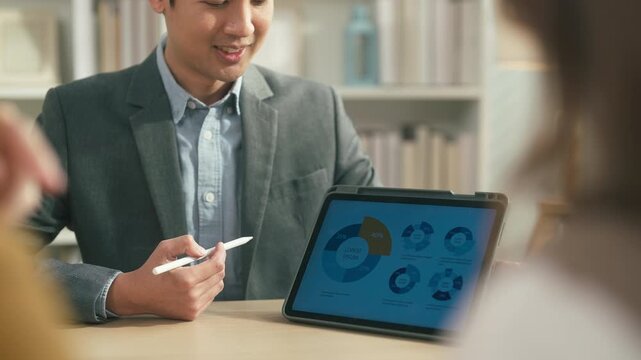 Professional financial advisor presenting investment and savings strategy to couple with tablet analytics, future wealth planning and personal finance consultation concept.	
