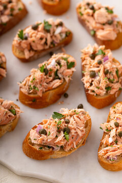 Hot smoked salmon crostini with smoked or roasted salmon, red onion and capers