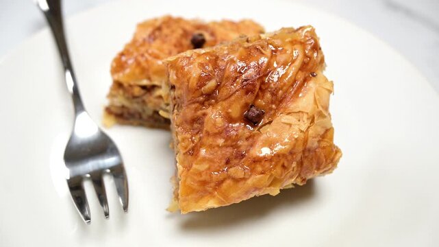 closeup of baklava pastry dessert on white dish