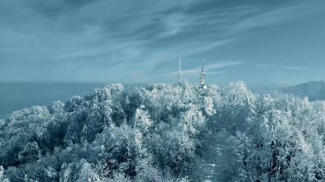Aerial Shot of Frosted Winter Forest and Communicatio Antennas on Hill