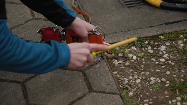 A climber meticulously sharpens the front points of their ice climbing crampons with a handheld file. This essential maintenance ensures maximum bite into hard ice during a winter ascent.