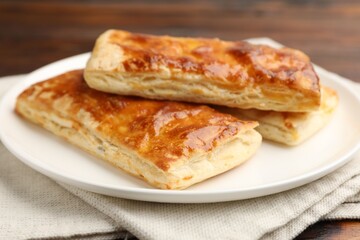 Tasty puff pastries on wooden table, closeup
