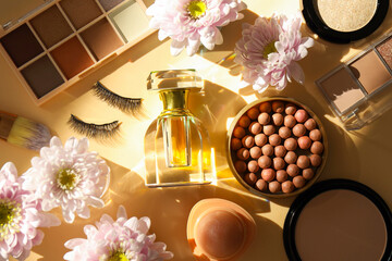Spring composition with different makeup products, perfume and pink chrysanthemum flowers on beige...