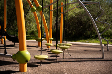 Modern playground swings and climbing structure with vibrant orange and green accents