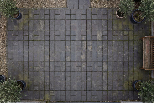 Top down view of dark grey rectangular paving stones arranged in courtyard pattern