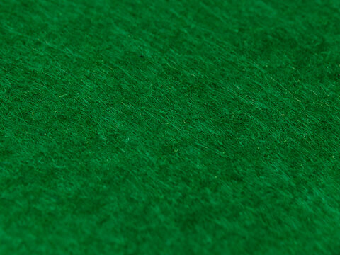 A high-resolution macro close-up showcasing the dense and fuzzy texture of a green felt or fleece fabric