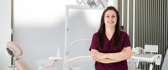 Dentist stands confidently in clinic with modern equipment during working hours © Marko