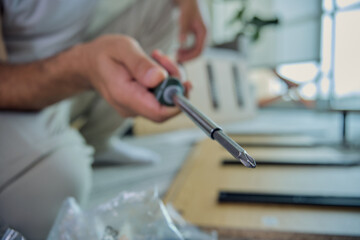 Fototapeta premium Person holding screwdriver assembling furniture at home