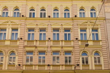Obraz premium Historic facades of a European city street, ornate architecture and aged buildings forming a timeless urban landscape filled with character and classical details.