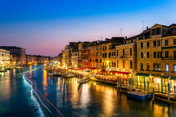 Long exposure of Grand Canal at dusk as viewed from Rialto bridge, Venice, Italy. Boats leave light trails forming the colors of the Italian flag.
