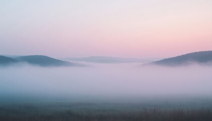 Obraz premium Misty mountain landscape at sunrise with soft fog and serene atmosphere in pastel colors