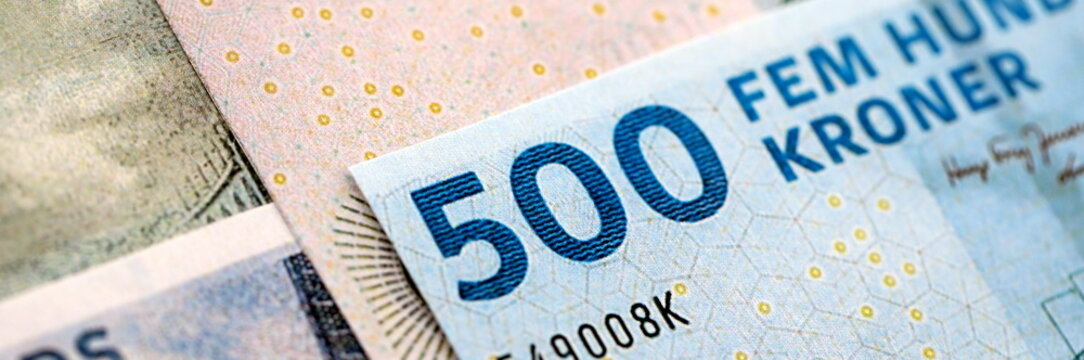 Danish krone paper banknotes pile on table. Denmark DKK currency money bills in big amount. Concept of economics, taxation and banking in Denmark