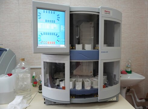 A Thermo Scientific Gemini AS automatic slide stainer stands in a clinical laboratory. The automated system processes histology slides for microscopic examination.  