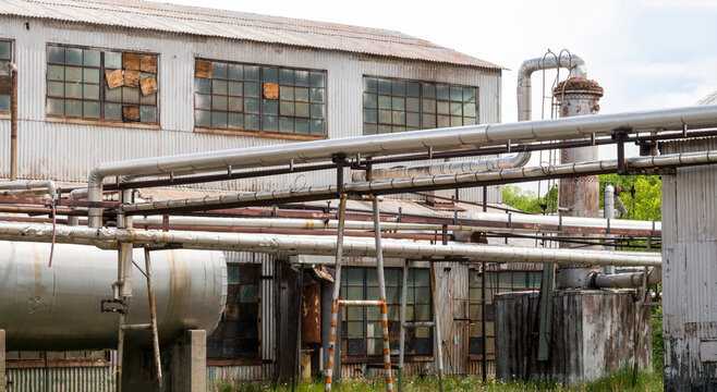 Canada, Alberta, Turner Valley.  Pipelines and rusted buildings at the Turner Valley Gas Plant, historic site.