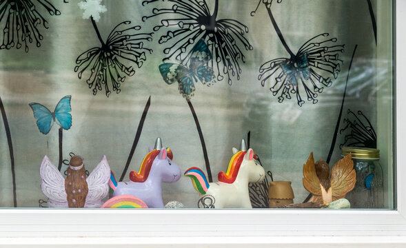 Canada, Saskatchewan, Regina.  Toy painted unicorn ponies on the windowsill of a home.