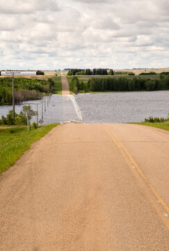 Canada, Saskatchewan, North Battleford.  Flooded road ahead in a low point in the prairie landscape.