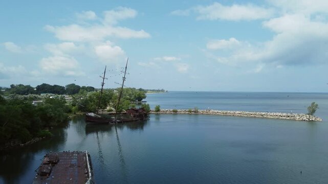 La Grande Hermine, also known as the Jordan Harbour Shipwreck, an ghostly pirate ship looking vessel visible along the QEW in southwestern Ontario, Canada, Lake Ontario. Aerial moving back.