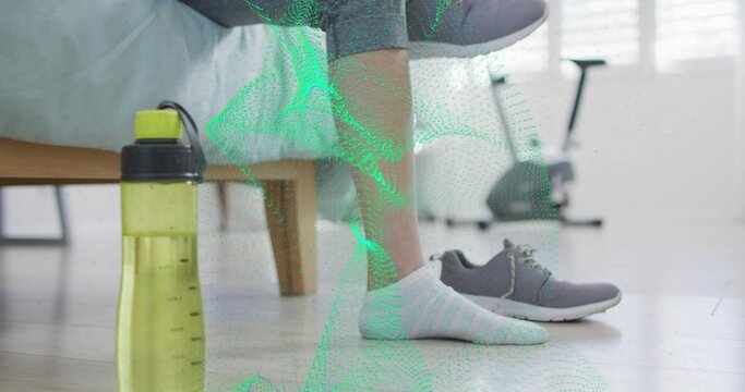 Showing lower legs wearing gray sweatpants and striped sock at bed edge, with yellow bottle, bike