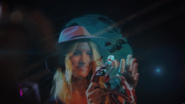 Vertical video: Cueing hat singer singing on stage into mic, shaking tambourine for fans with globe