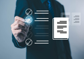 Business professional touching a virtual checklist with glowing check marks and document icons,...