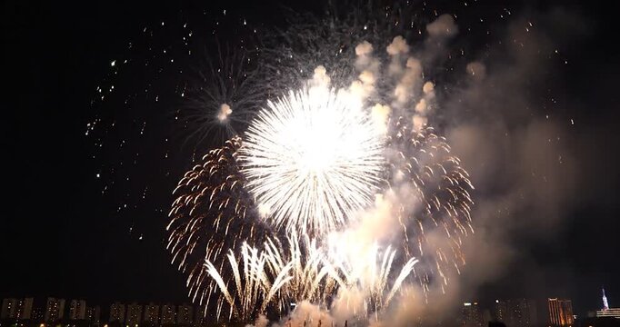 Vibrant fireworks exploding over city skyline at night