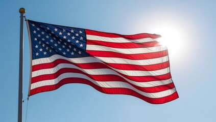 Obraz premium Vibrant national banner with distinctive stars and stripes proudly waving under bright sunlight against a clear blue sky, symbolizing unity and independence