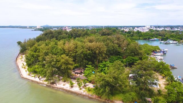 Drone shot of Tanjung Pendam park in Belitung, Indonesia. Featuring green trees and sandy shores, it's a top urban sunset destination.