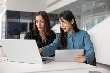 Positive young Asian and Middle Eastern managers working on online project strategy together,...