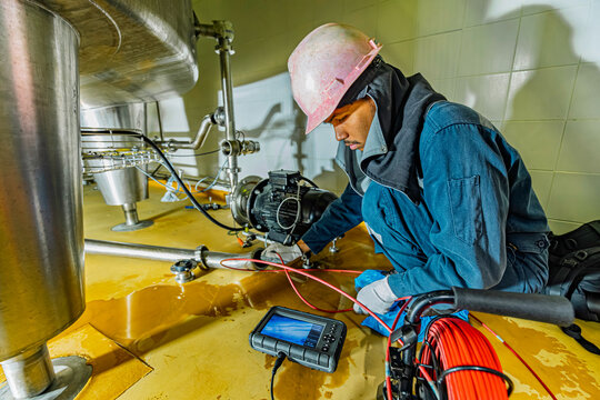 A man starts using a weld pipe stainless inspection camera. The light monitor shows images from the camera head