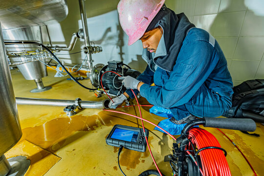 A man starts using a weld pipe stainless inspection camera. The light monitor shows images from the camera head