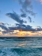 Fototapeta premium Dramatic Sunset over the Turquoise Ocean with Majestic Golden Sunbeams