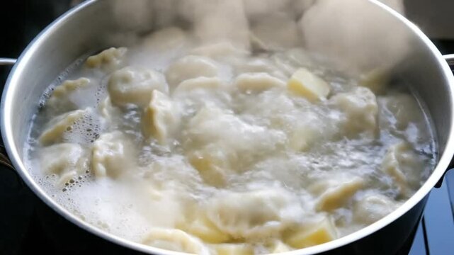 Boiling pierogies and potatoes in a silver pot, cooking in hot water, food preparation