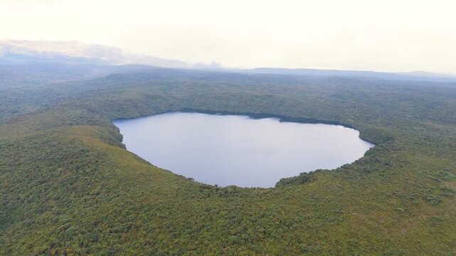 Aerial shot showcasing the tranquil Buey Lagoon surrounded by lush greenery in Purace National Park, Colombia.