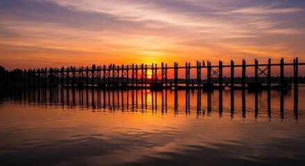 Fototapeta premium U Bein Bridge at Sunset - A Serene Reflection in Myanmar.