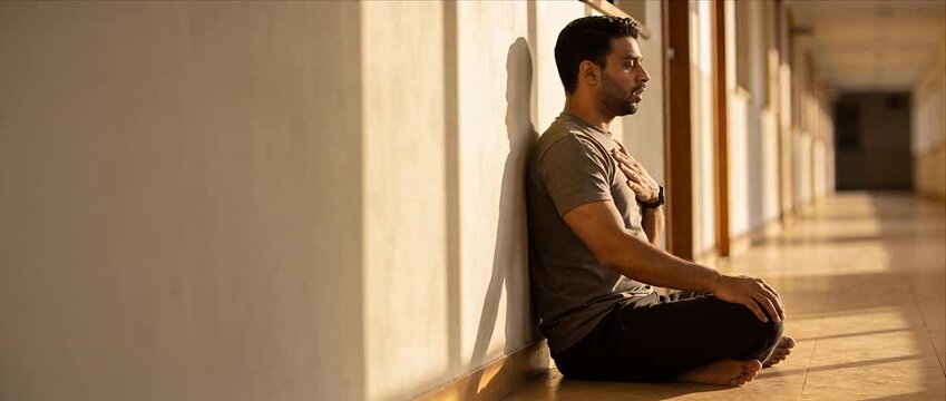 Calm adult man male sitting floor corridor hallway meditation yoga breathing calm relax health mindfulness indoor session relaxed breathing practice mental health focus stress relief self care