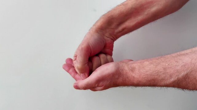 Two hands in a rock, paper, scissors gesture, with one clenched fist and the other open palm, symbolizing play, decision making, and a universally recognized hand game