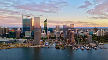 Fototapeta premium Perth City at Sunrise, Western Australia – 4K Aerial Drone View of Skyline, Swan River, Central Business District, CBD, Modern Skyscrapers, Waterfront Marina, Swan River and Golden Morning Light