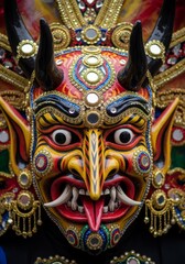 Naklejka premium Traditional ornate demon mask from Sri Lanka. Handcrafted wooden raksha mask with intricate details and colorful paint. Cultural heritage and folklore symbol for ceremony or ritual.