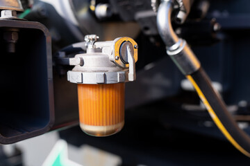 Industrial fluid filter assembly with transparent reservoir and metal cap, illustrating mechanical upkeep, equipment diagnostics and system care