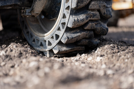 Heavy duty off road machinery tire pressed into gravel, highlighting ground traction, equipment durability and construction site performance