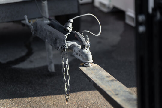 Utility trailer drawbar with hitch lock, chain and cable connector, representing towing equipment, fleet support and loading operations