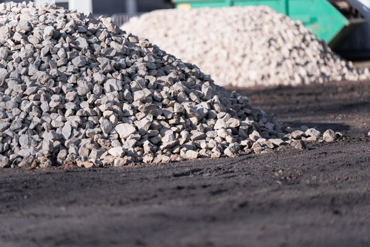 Pile of crushed stone on a construction site with another aggregate mound behind, highlighting material supply, ground preparation and site logistics