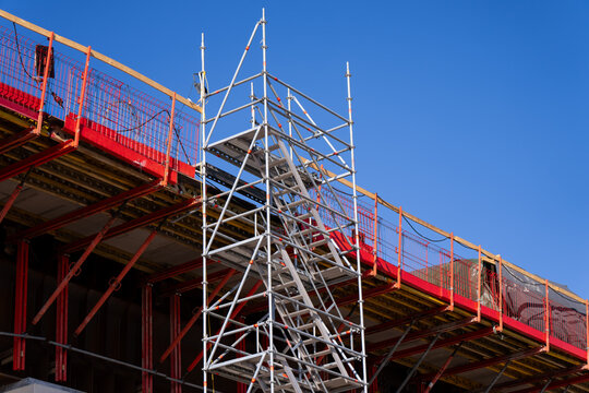 Bridge construction platform with scaffold tower and red edge protection, representing civil engineering workflow, site safety and transport development