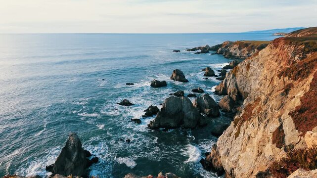 Crashing waves meet the rugged cliffs of Bodega Head at sunset