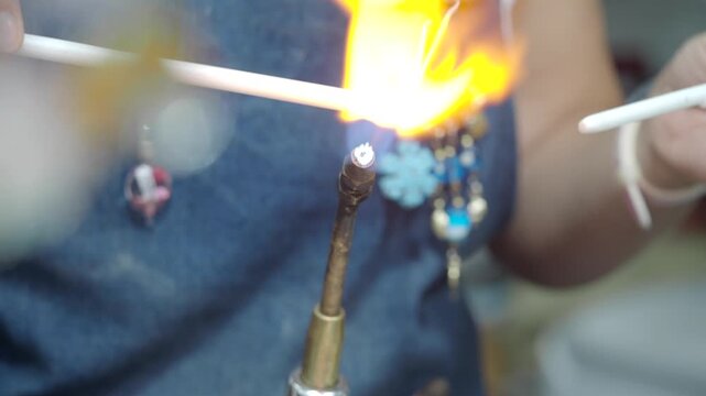 Close Up of Artisan Melting Glass Rod with Torch for Glass Blowing