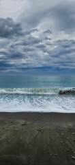 Stormy ocean waves crashing on a pebble beach under overcast clouds moody seascape